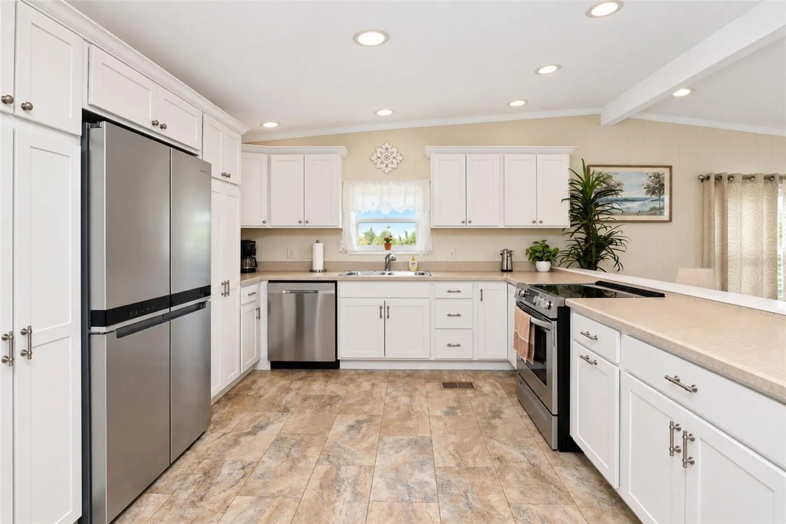 The kitchen features a Whirlpool French door refrigerator, Samsung dishwasher and Frigidaire smooth top stove.