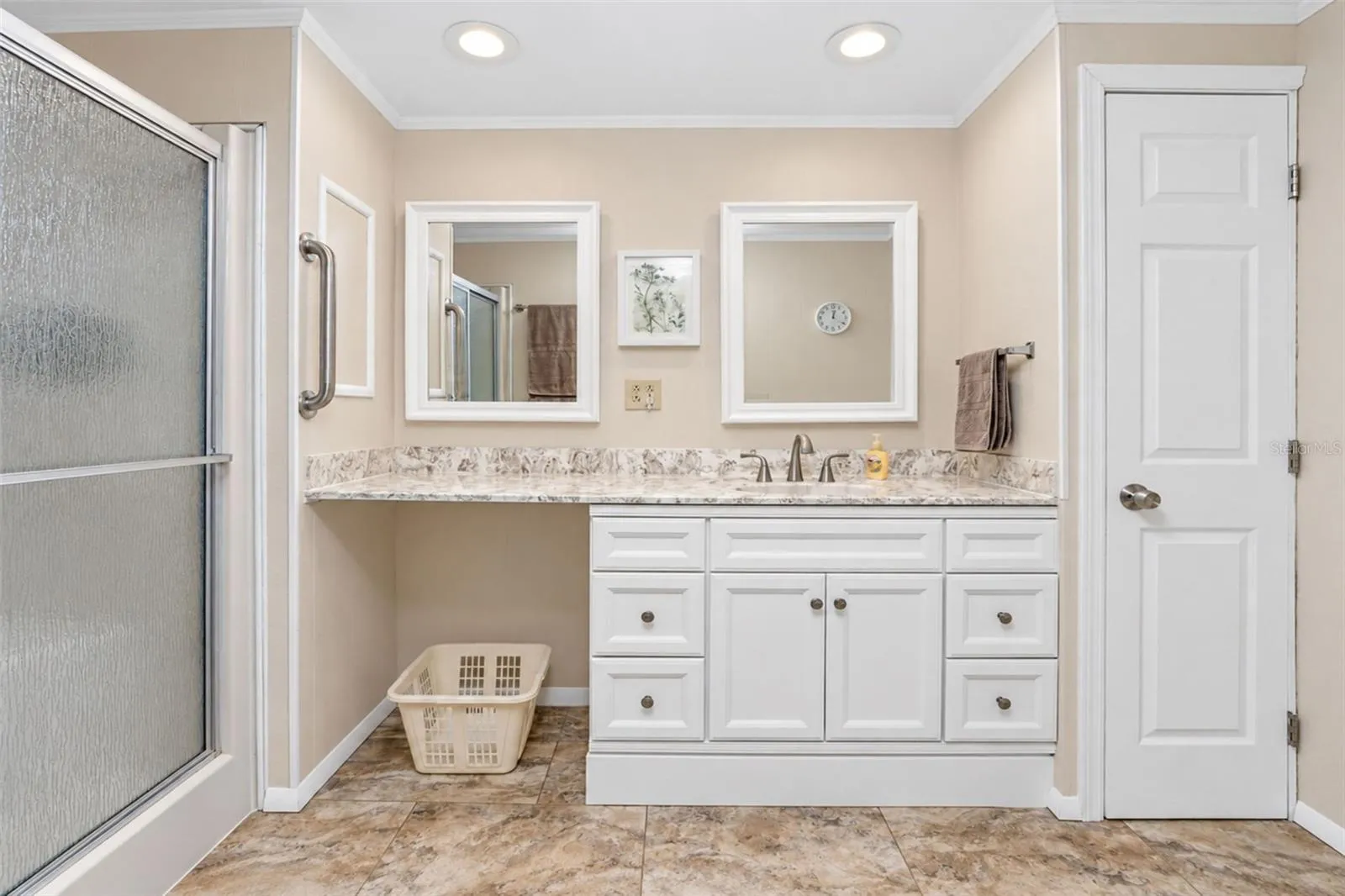 The en-suite bathroom features a new vanity with solid surface countertop, new mirrors and a linen closet for storage.