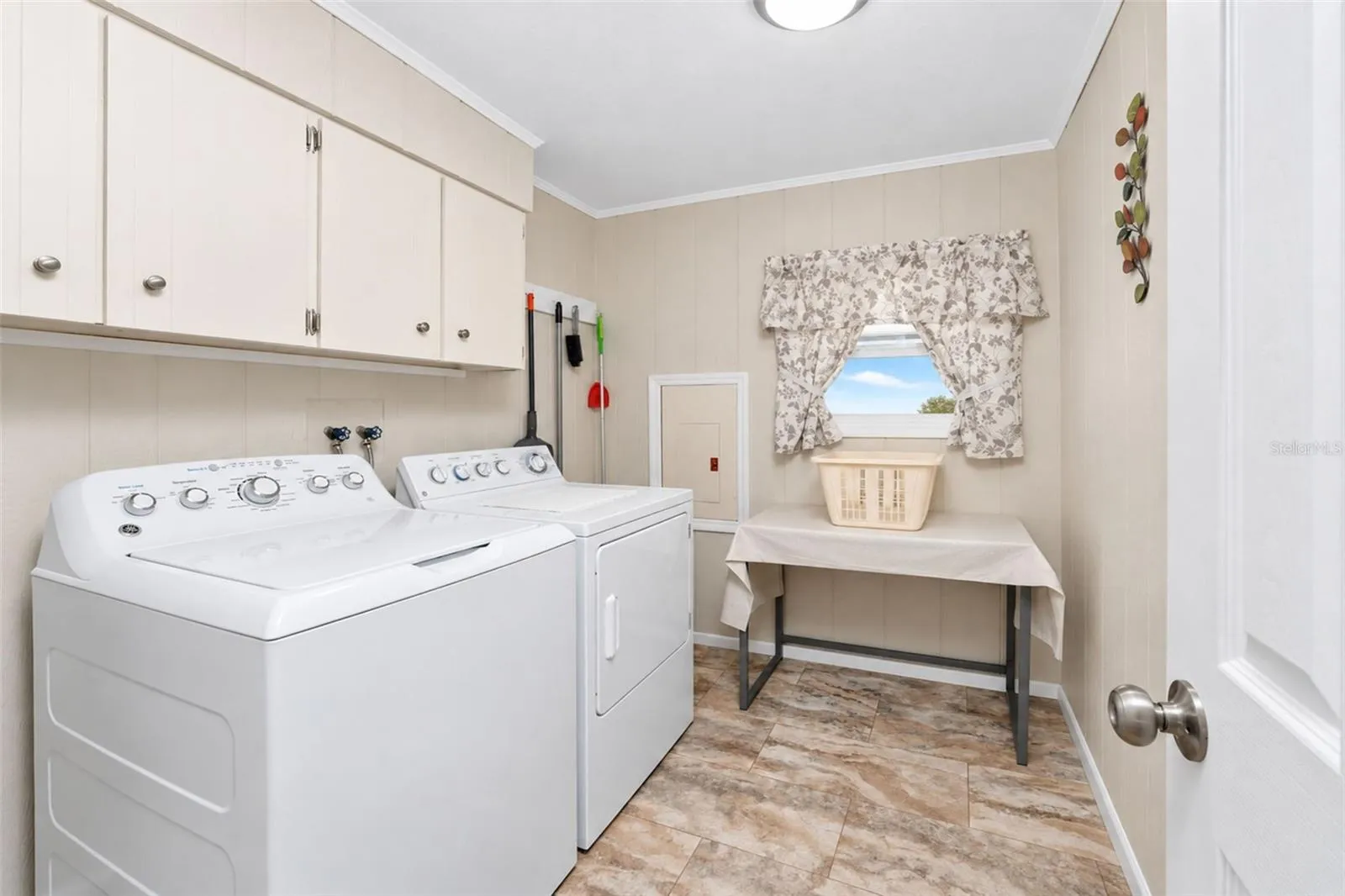 The inside laundry room features a GE washer and dryer plus upper cabinetry