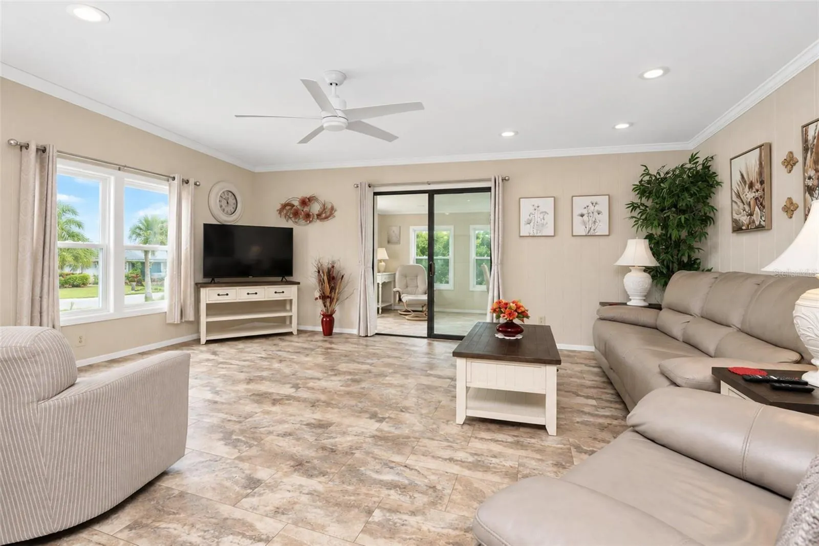 The inviting living room features LVP flooring and a ceiling fan.