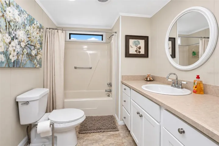 The guest bathroom features a combination tub/shower and a new toilet.