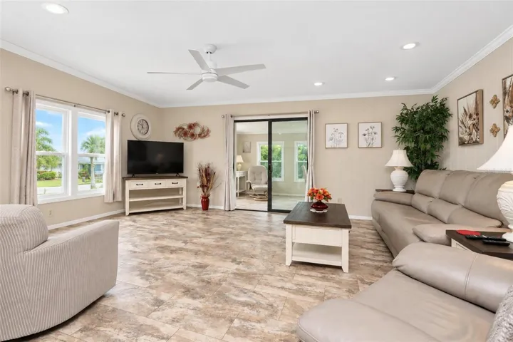The inviting living room features LVP flooring and a ceiling fan.