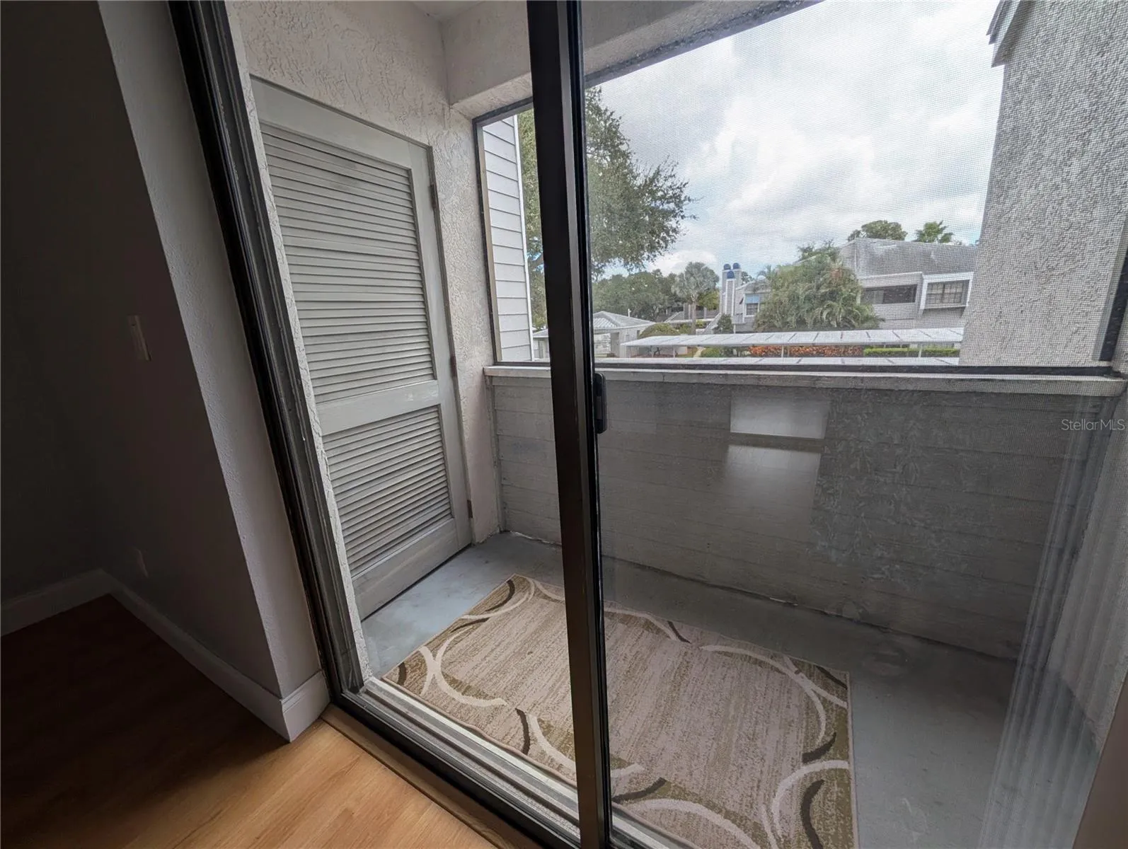 2nd bedroom with slider to private patio and outdoor storage closet