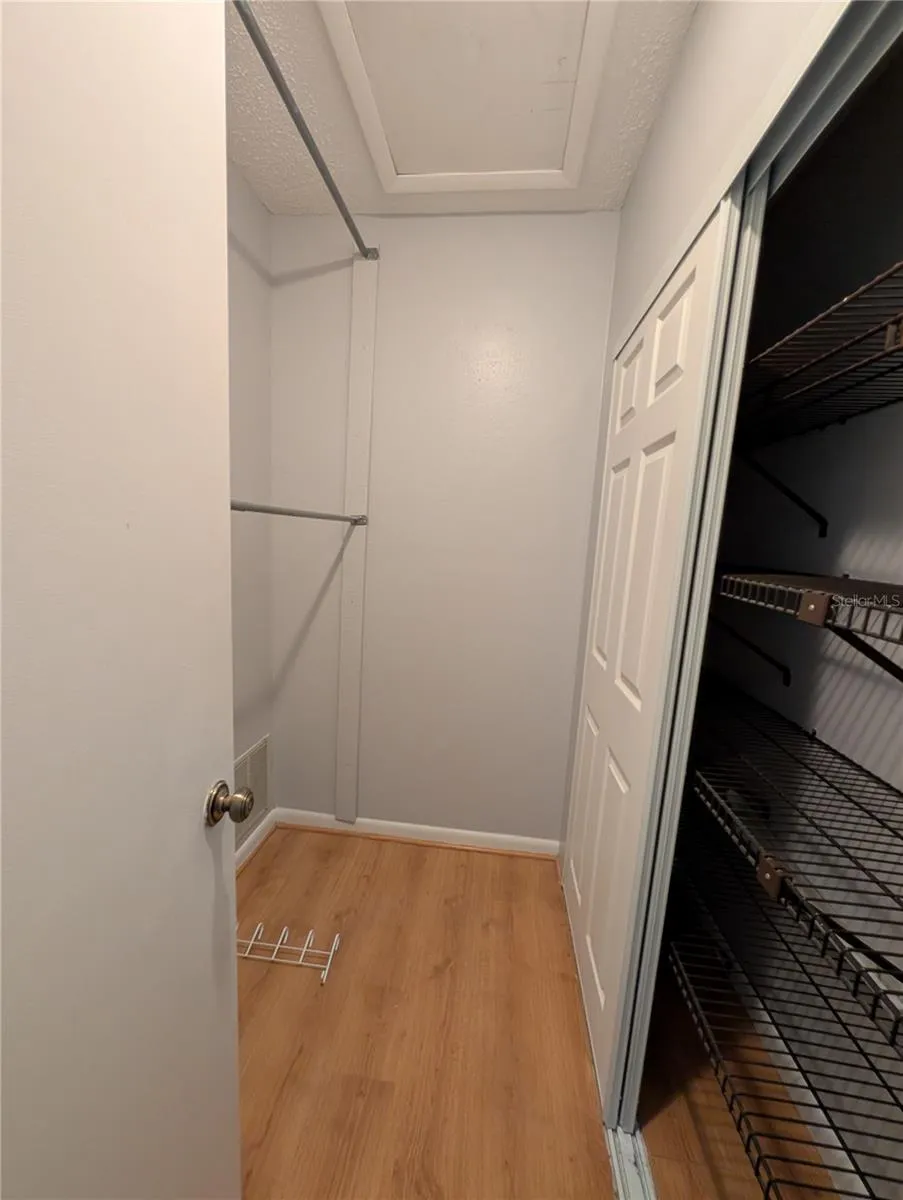 Primary walk in closet with access to attic
