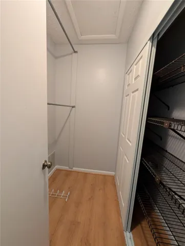 Primary walk in closet with access to attic