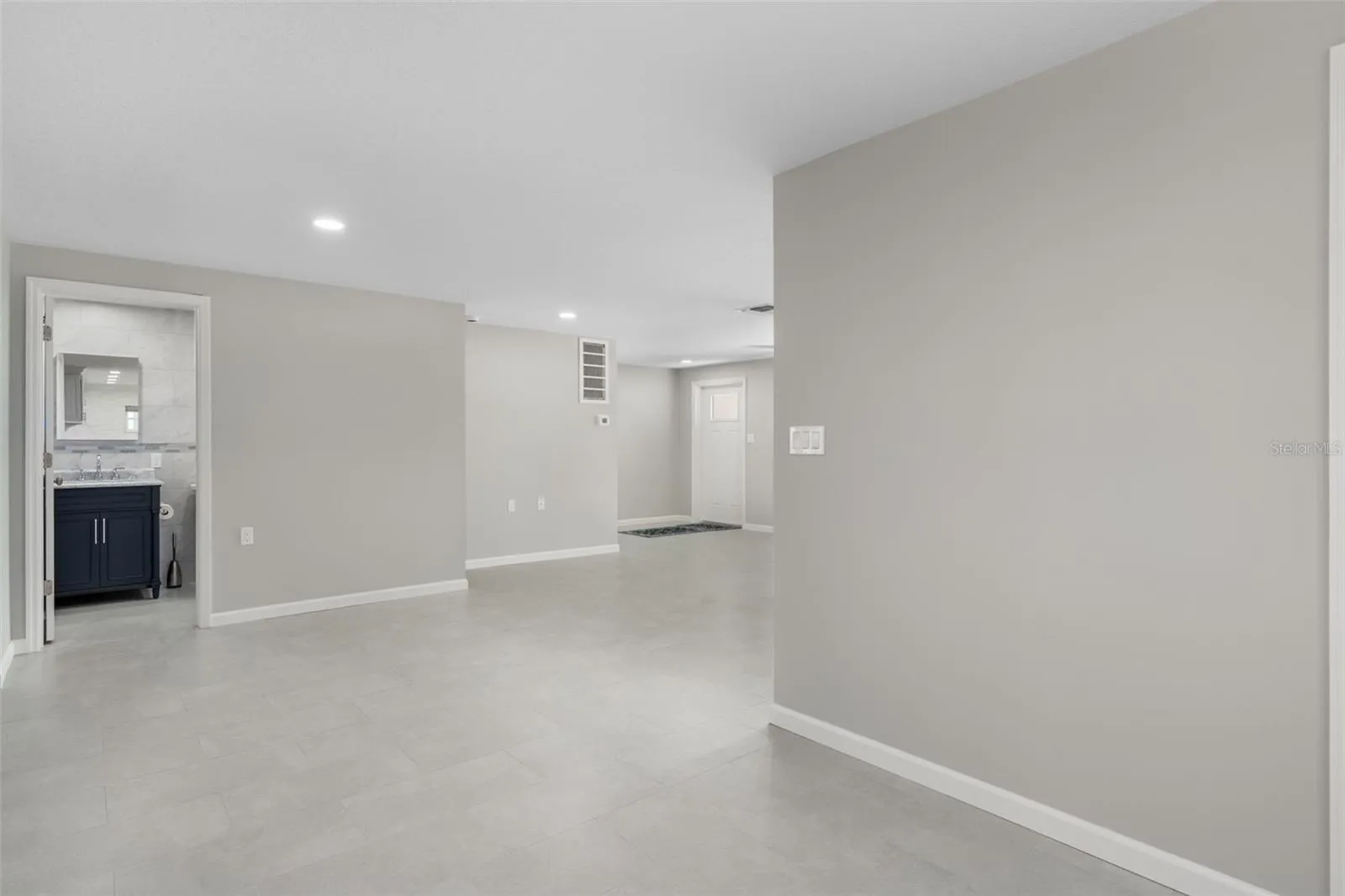 Standing in kitchen looking toward dining and living rooms with bath