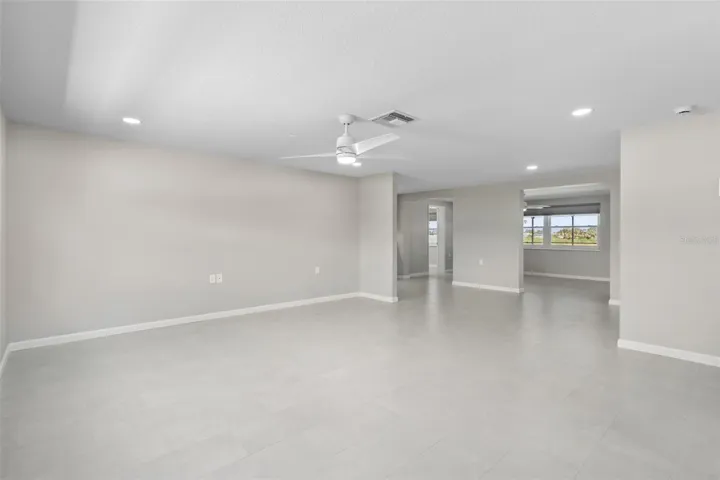 Living room looking into dining room and bonus room. BRAND NEW PAINT, NEW ELECTRIC, NEW TILE, WALL AND CEILING NEW CEILING AND WALL TEXTURE, NEW FANS/LIGHT FIXURES