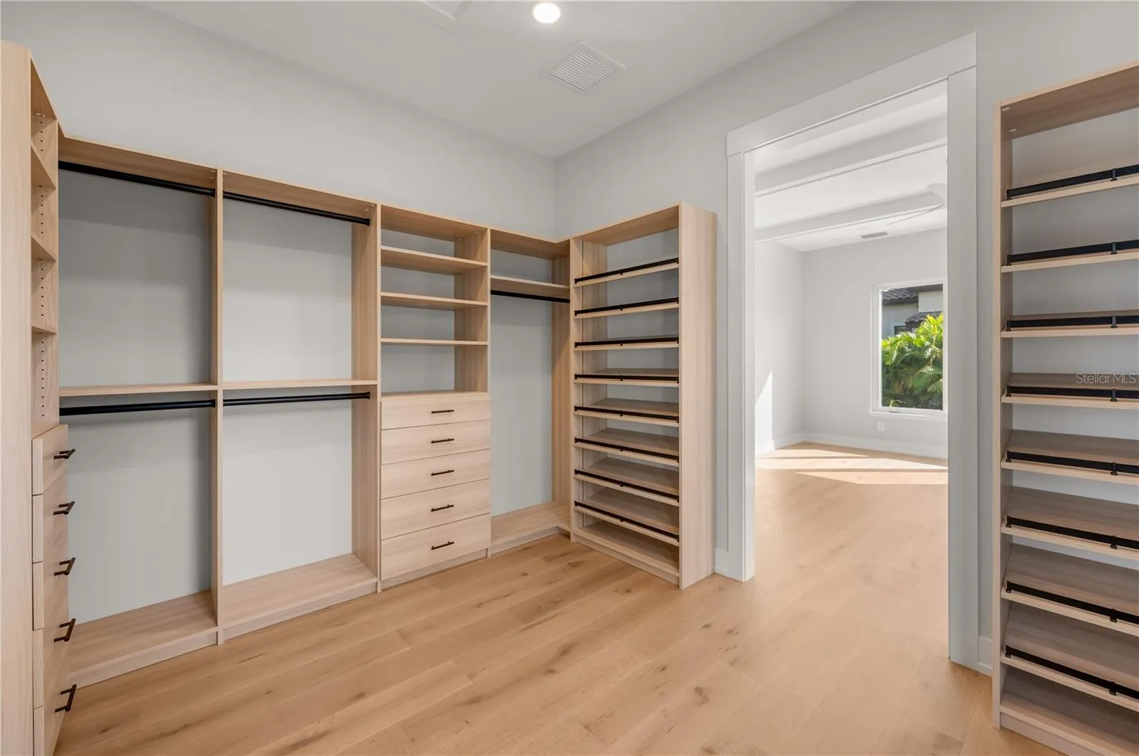 Primary bedroom walk in closet with built in closet system.