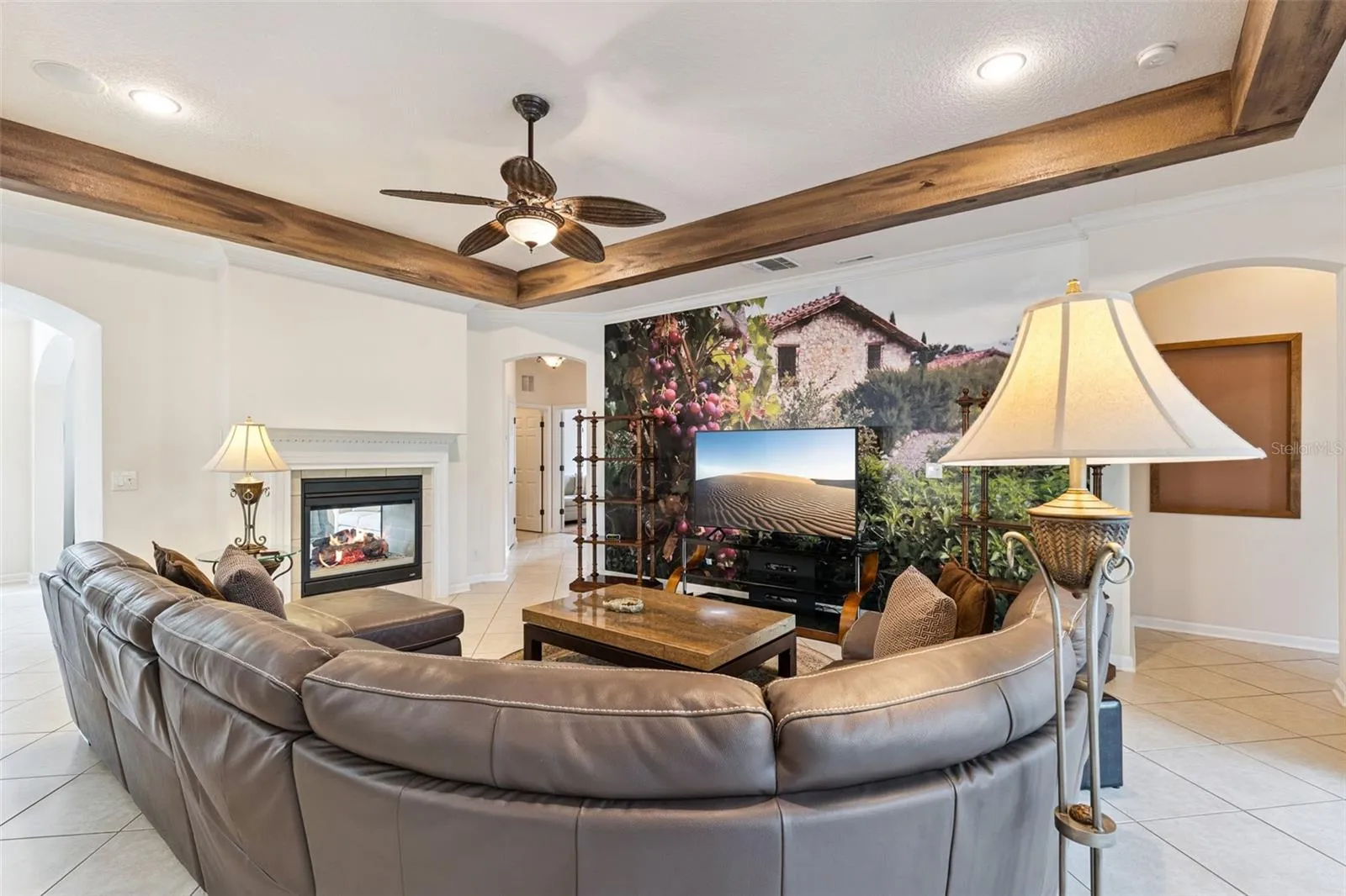 Family Room w/ a double sided natural gas fireplace, decorative accent wall &amp; crown molding