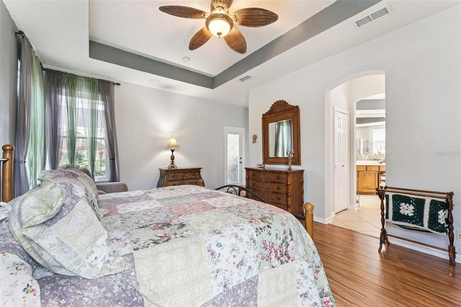 Primary Bedroom w/ a French door that leads to the screen enclosed covered patio