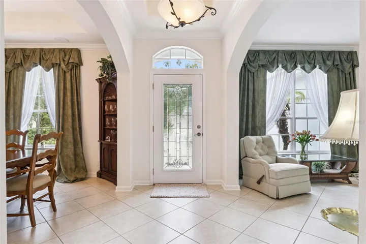 Foyer entryway w/ leaded glass front door, tray ceiling &amp; crown molding