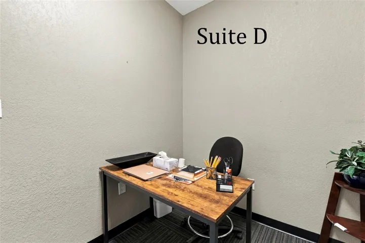 Suite D has a high window and is located near the hall restroom and Covered Patio Break Common Area