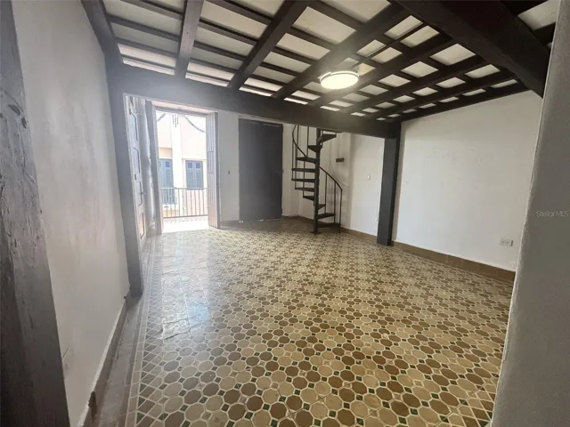 Living room with two doors to the balcony and the spiral staircase
