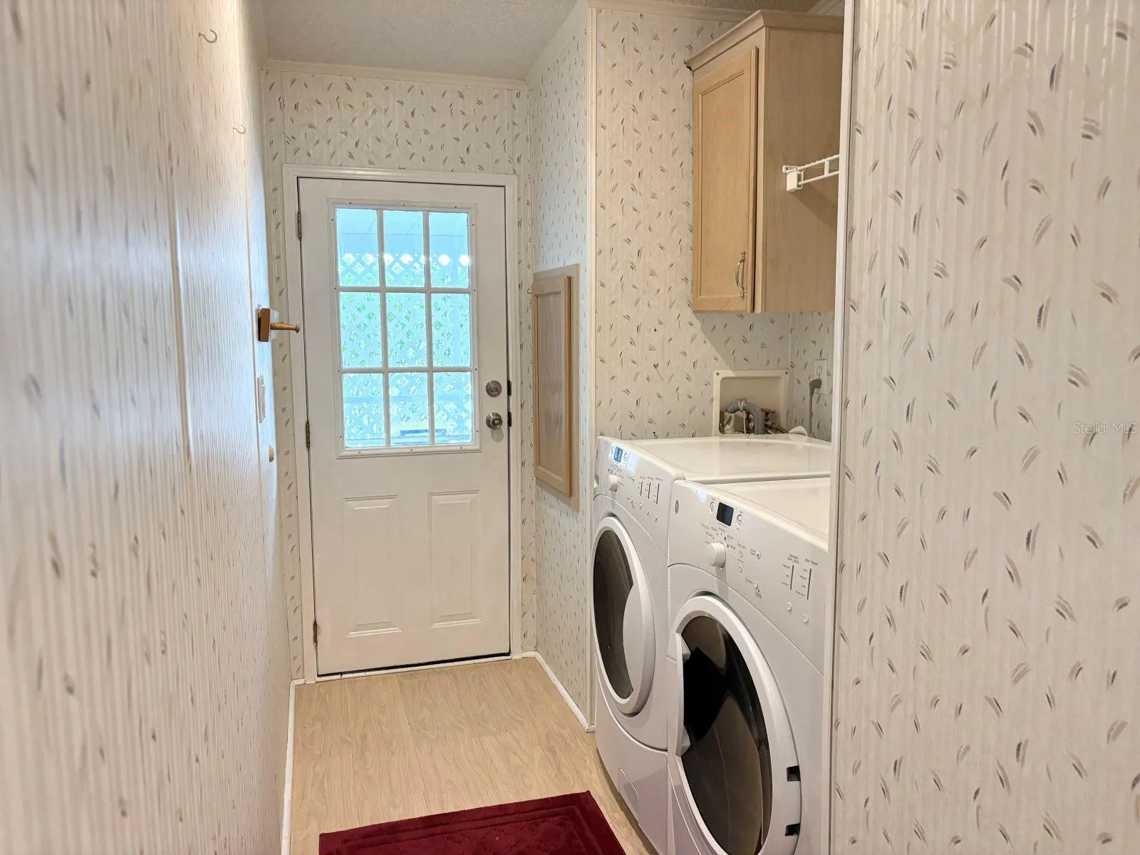 Laundry room with access to carport and storage shed