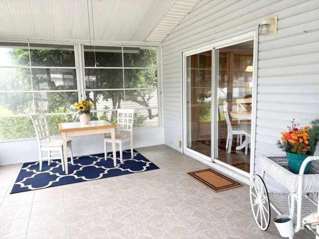 Vinyl window enclosed porch with slider to kitchen
