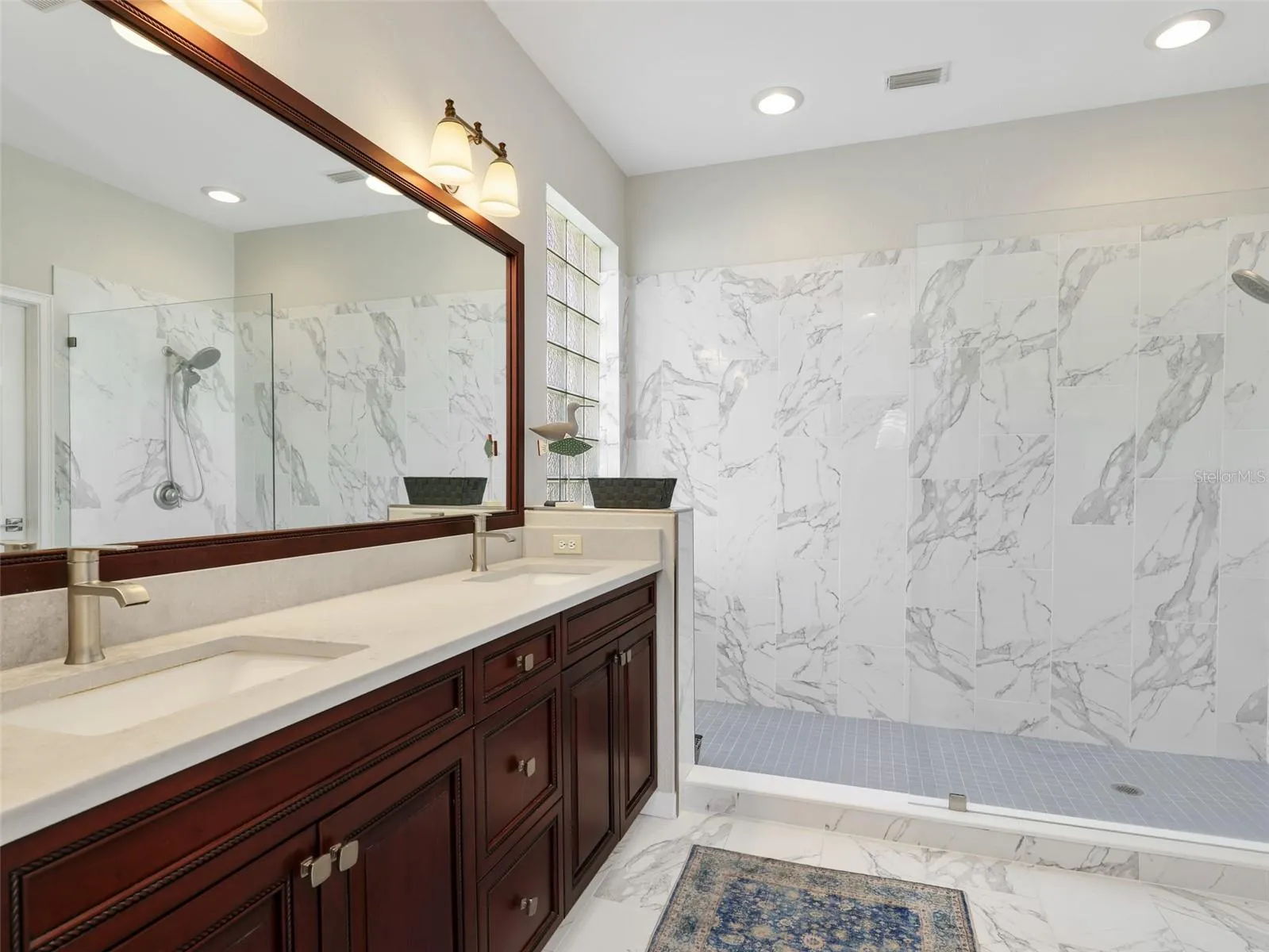 Updated primary bath with dual vanities and an oversized walk-in shower.