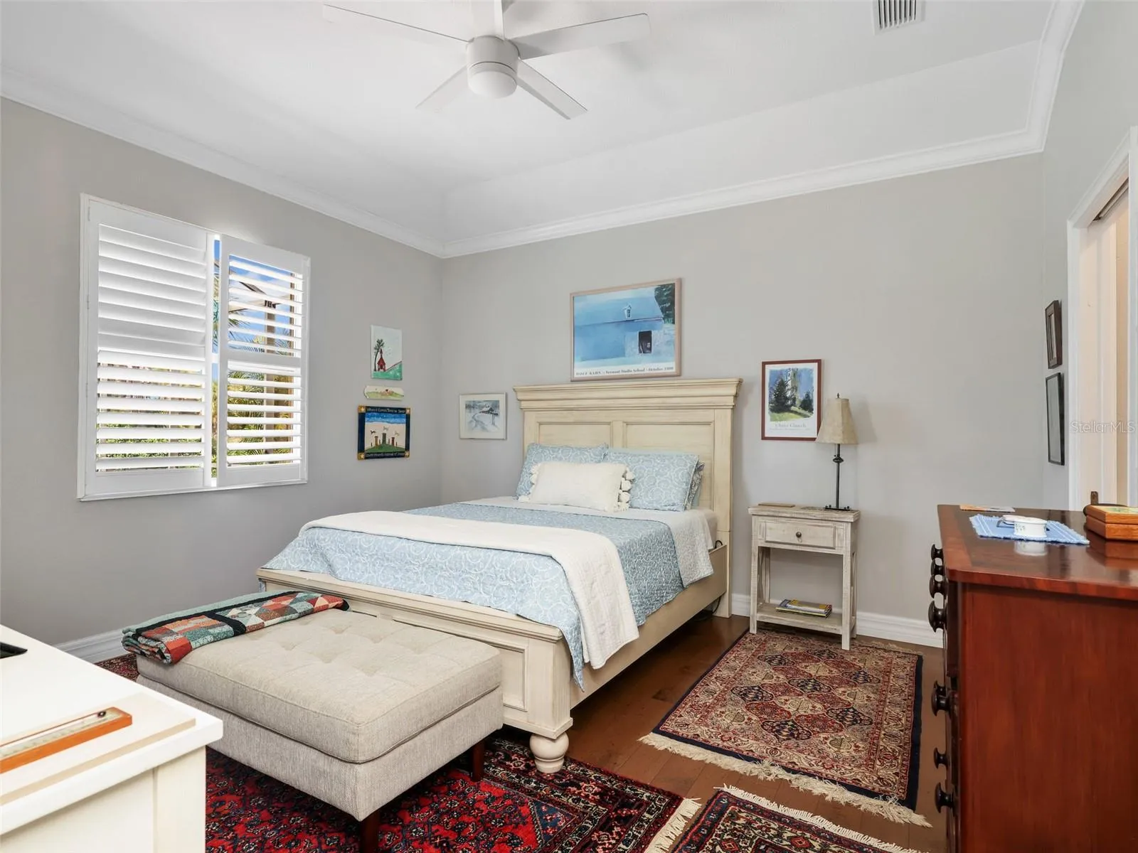 Spacious primary bedroom with high ceilings and plantation shutters