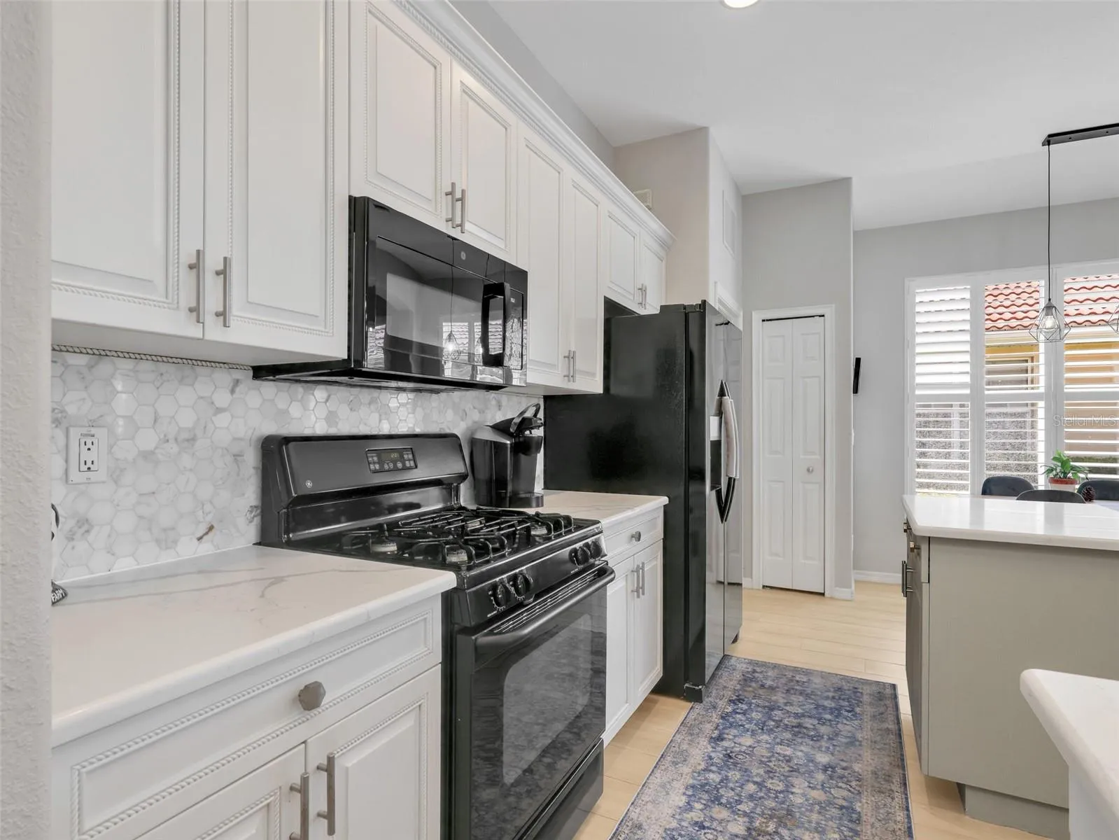 Natural gas range, tile backsplash, and updated countertops complete the kitchen.