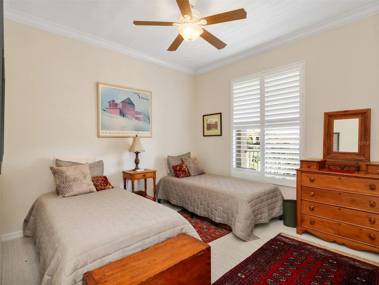 Bright guest bedroom with plantation shutters and crown molding