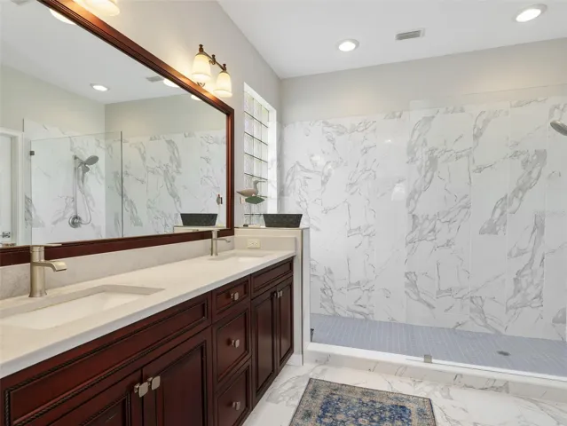 Updated primary bath with dual vanities and an oversized walk-in shower.