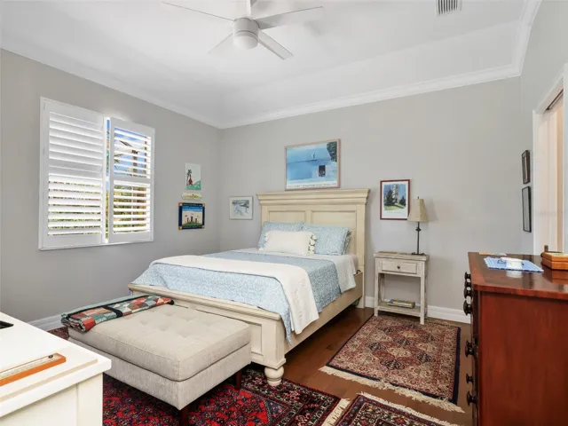 Spacious primary bedroom with high ceilings and plantation shutters