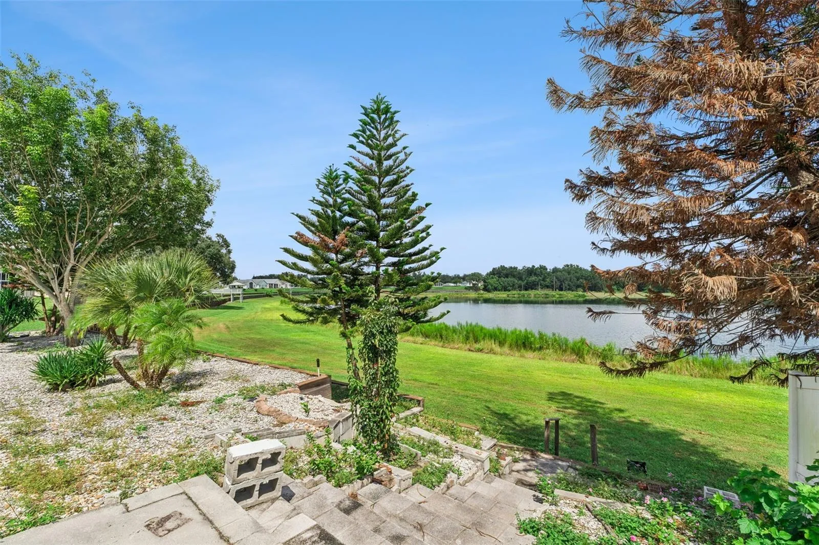 Private backyard with stairs leading directly toward the shoreline