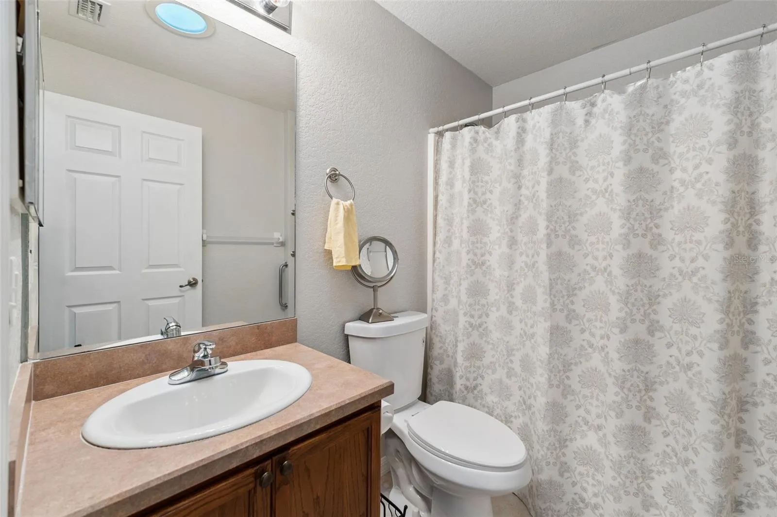 Guest bathroom features a tub/shower unit with solar skylight