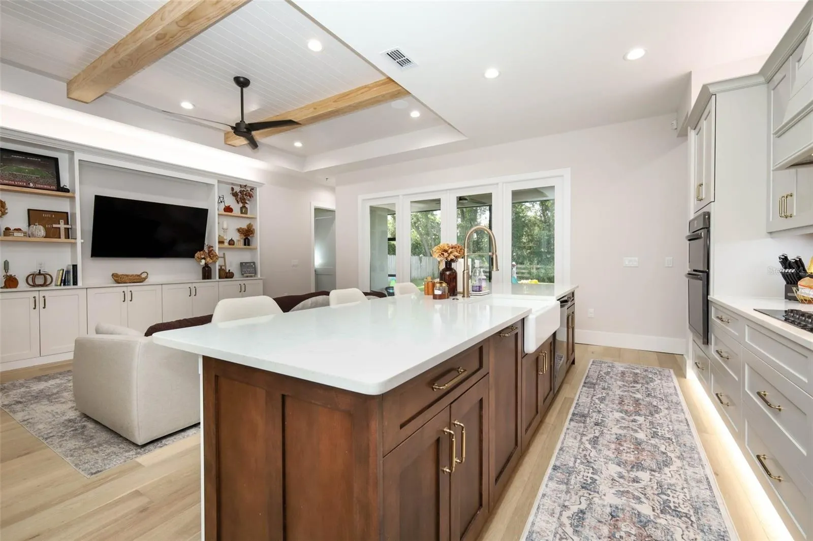 View of kitchen island equipped with quartz countertops and gold accents