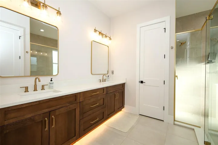 Spa like owners bathroom with under cabinet lighting, large linen closet and private water closet