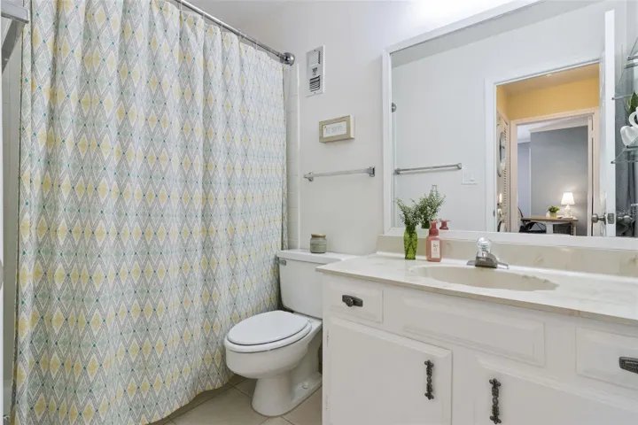 The second bathroom features a marble vanity with integrated sink and tub with shower.