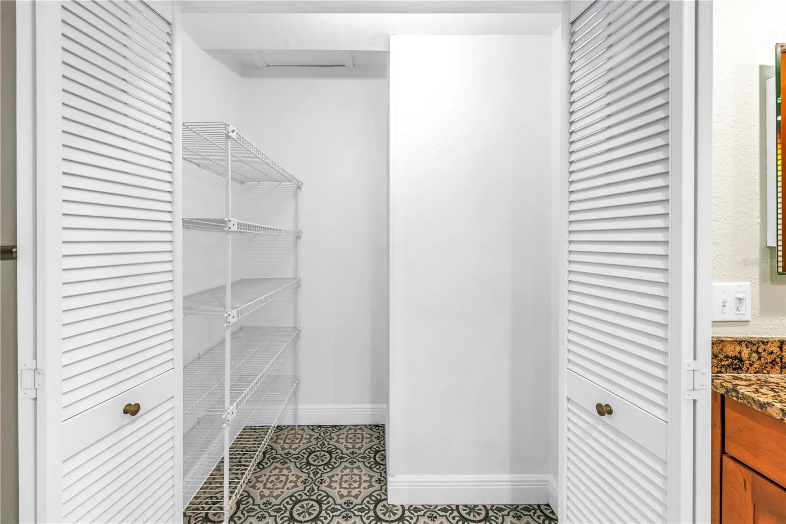 The primary suite features an expansive walk-in linen closet, updated with flooring that matches the primary bath floor.