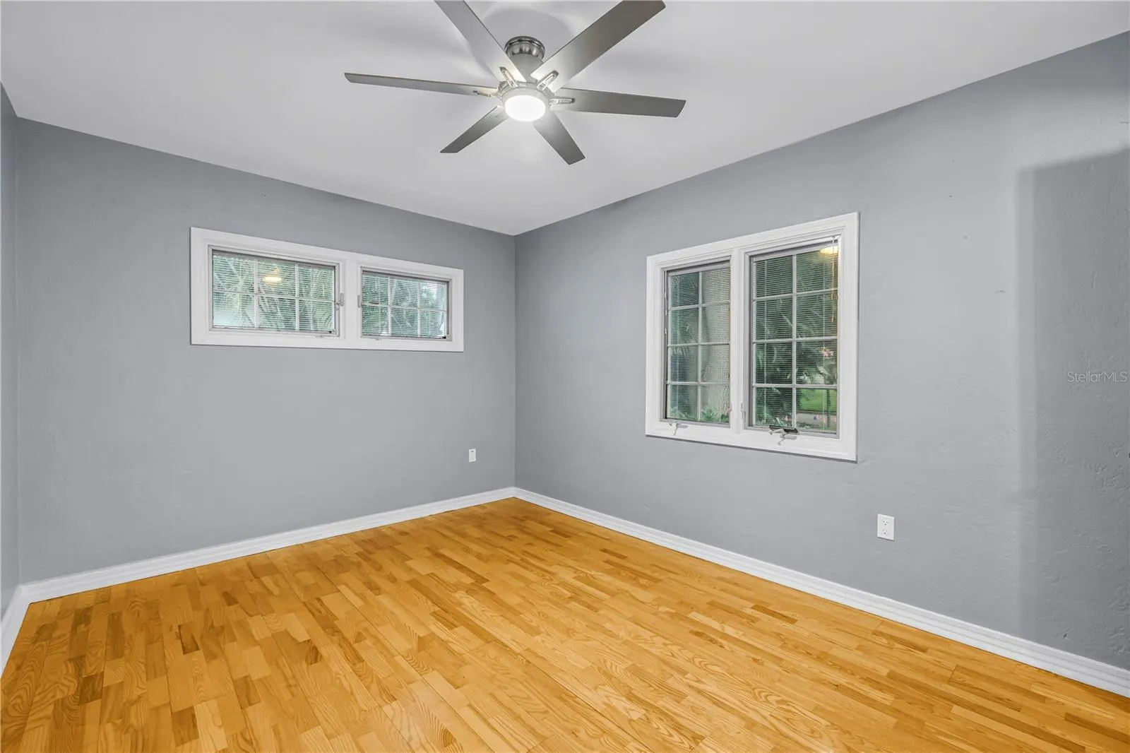 Spacious second bedroom with energy-efficient dual-pane windows, natural light, noise reduction, private half bathroom, and an expansive walk-in closet.