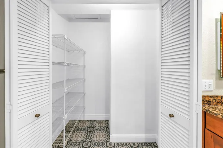 The primary suite features an expansive walk-in linen closet, updated with flooring that matches the primary bath floor.