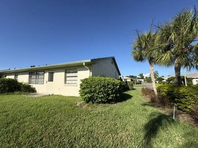 Back of home, pretty Florida landscaping features on this corner lot.