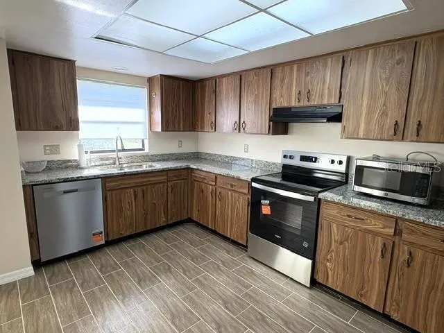 Kitchen is updated with beautiful stainless appliances, ceramic tile flooring and granite countertops.
