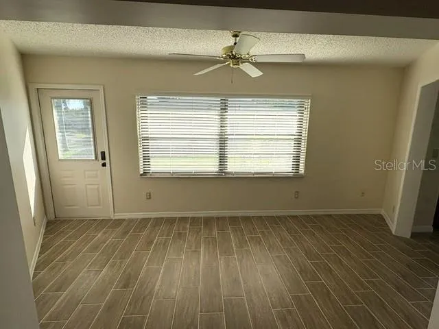 Enclosed lanai with door to the back yard.  Morning sun is beautiful in this room, a great place for that morning cup.