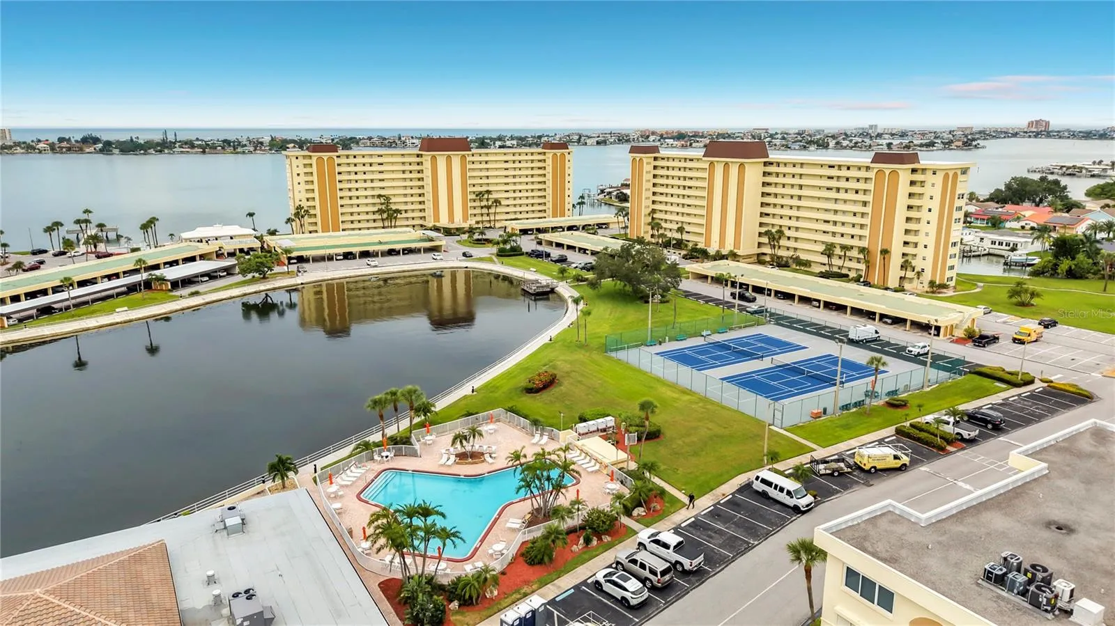 Resort-style community view featuring the Washington building, tennis and pickleball courts, and sparkling pool- all nestled around the tranquil bayou