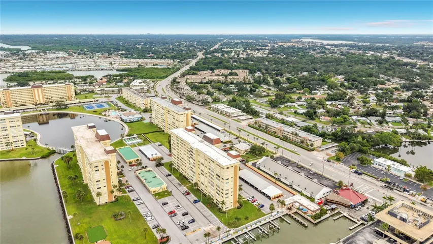 Resort-style community view featuring the Washington building, tennis and pickleball courts, and sparkling pool- all nestled around the tranquil bayou