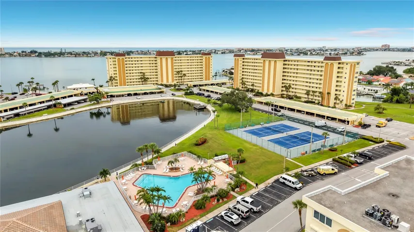 Resort-style community view featuring the Washington building, tennis and pickleball courts, and sparkling pool- all nestled around the tranquil bayou