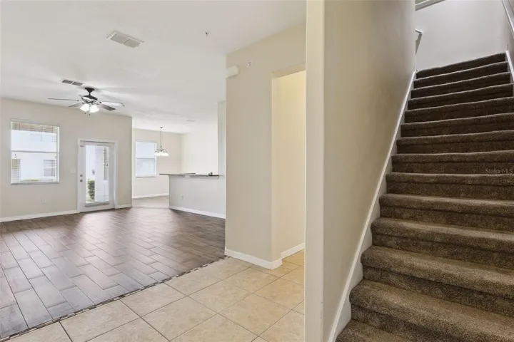 stairway going up, looking towards living room and kitchen