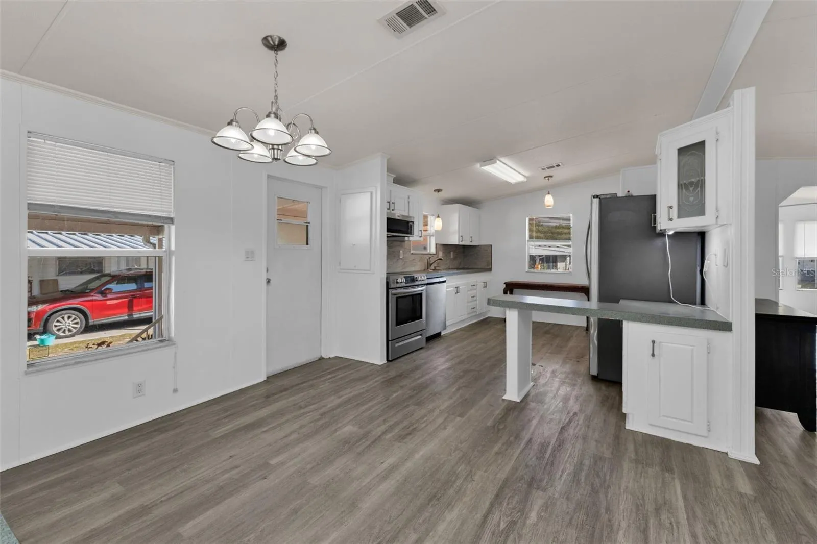 Kitchen and dining room with side entrance to carport/shed area.