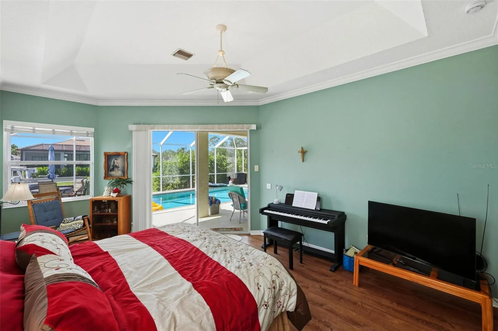 Sizable primary bedroom suite with alcove sitting area and sliders opening to the pool &amp; lanai.