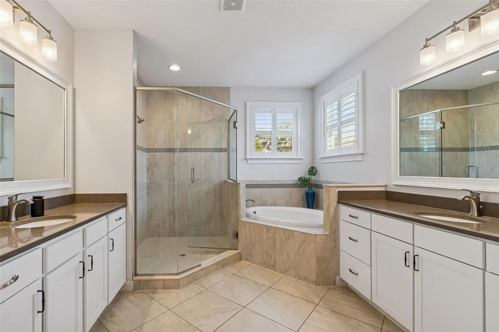 The primary bathroom features dual vanities, quartz finishes and a spacious layout.