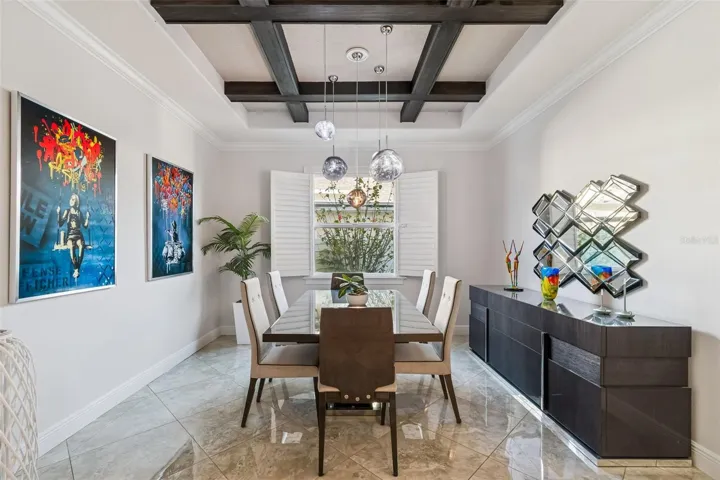 A formal dining room with a coffered ceiling, just beyond the foyer.