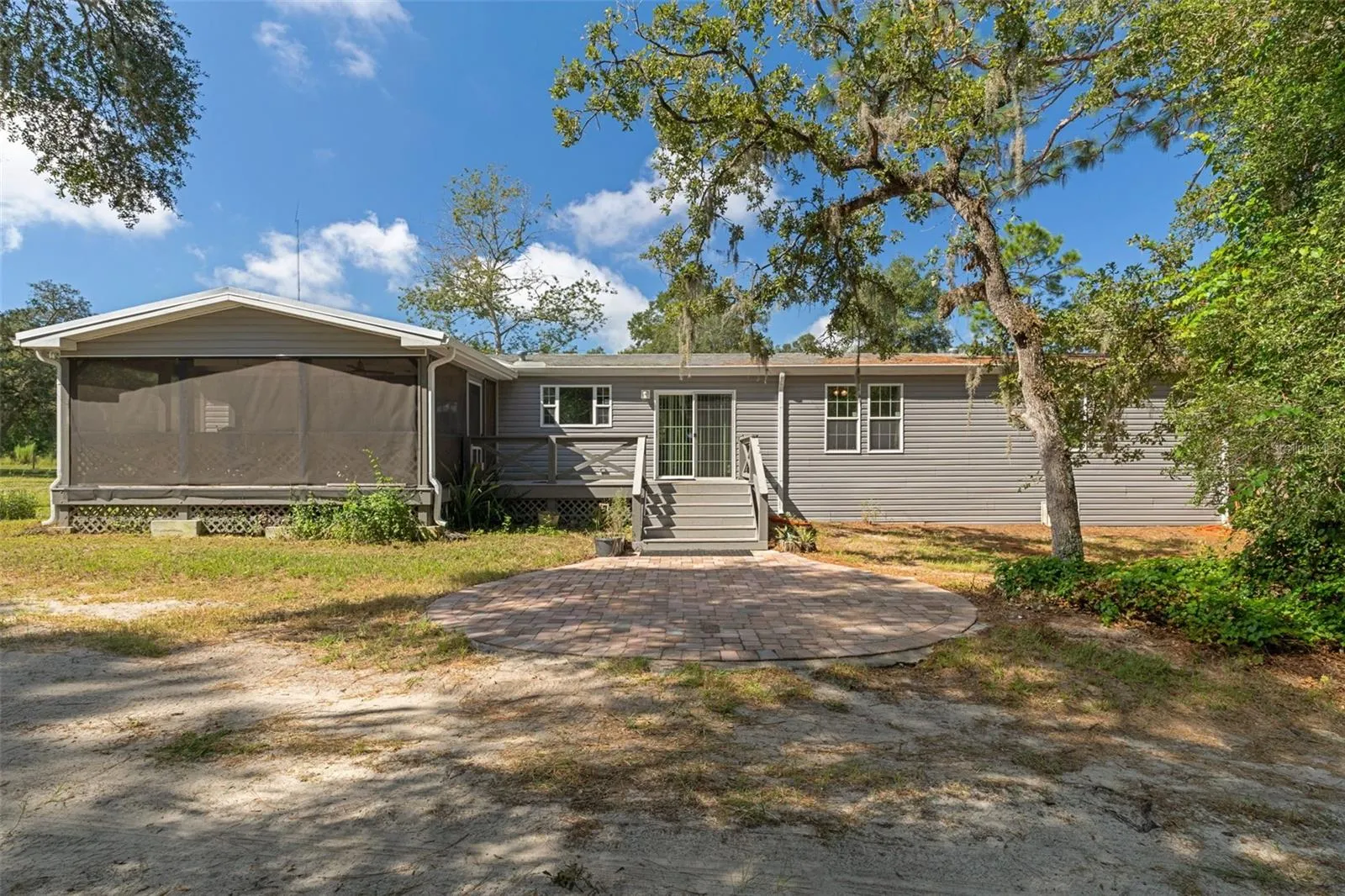 Rear exterior showing the connection between the home, screened porch, deck and pool area.