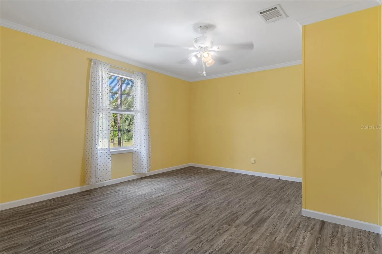 Unstaged Bedroom 2 with LVP flooring and natural light with access to Jack and Jill bathroom.