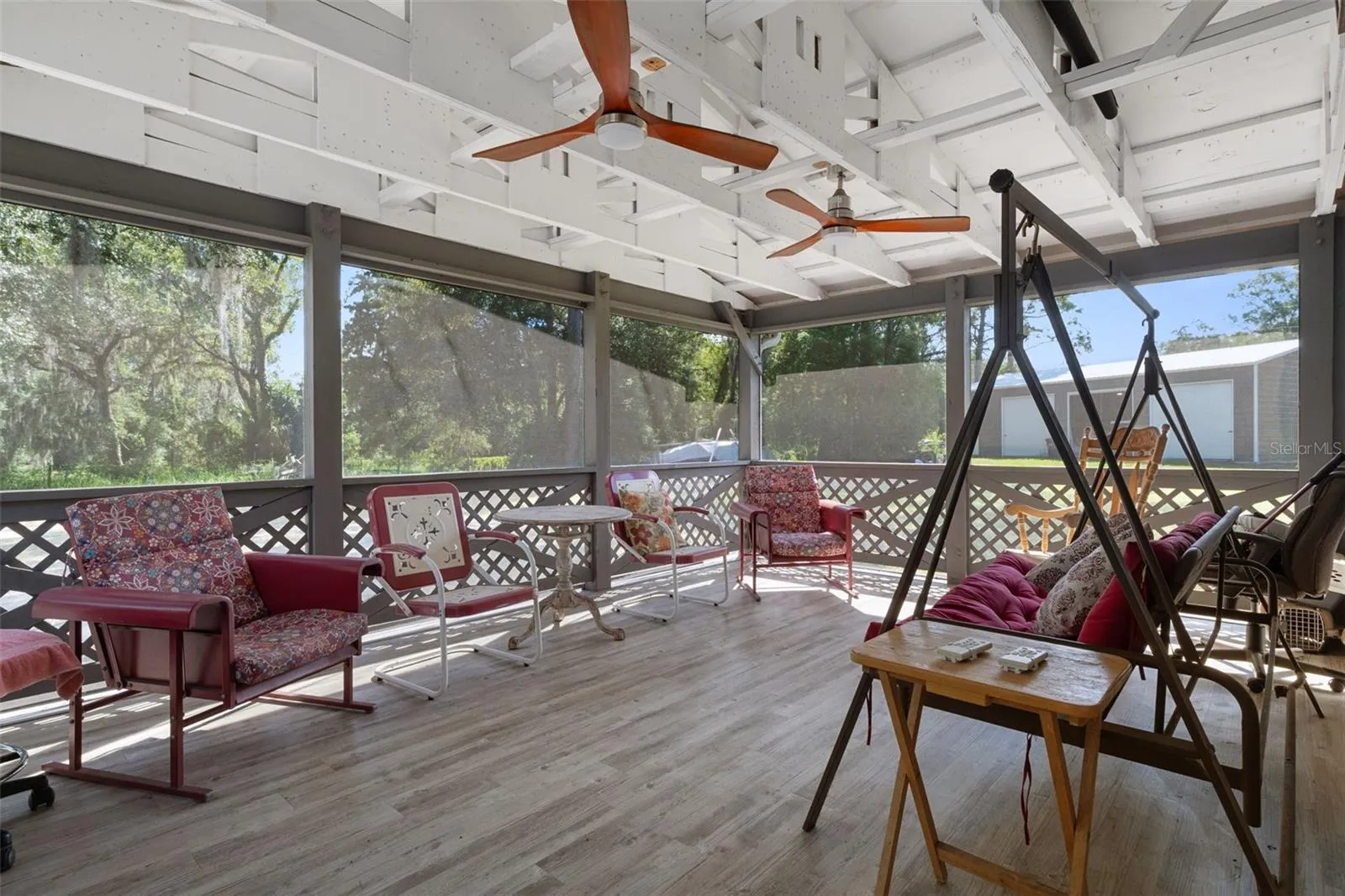 Expansive Screened porch with rustic timbers and dual ceiling fans extends the living space outdoors.