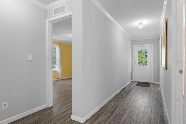 Additional view of hallway, bedroom 2 and bath 3 with LVP flooring and exterior door to pool area.