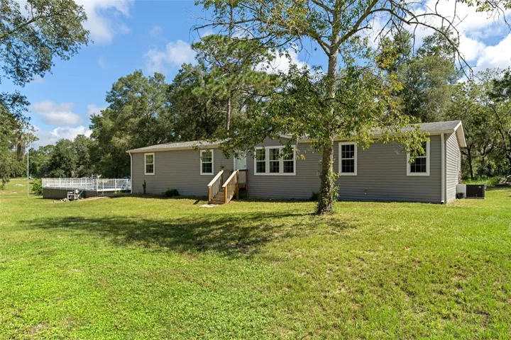 A different perspective of the home, pool and spacious property settings.