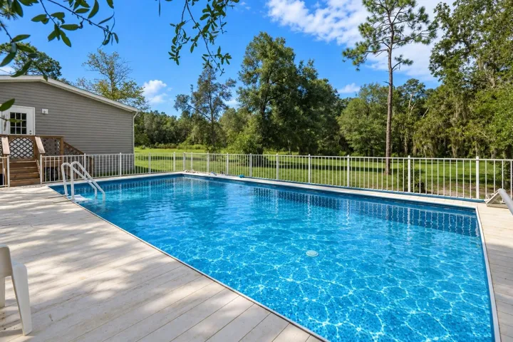Pool and sundeck offer additional space for relaxing and outdoor entertaining. Pool water virtually enhanced for presentation.